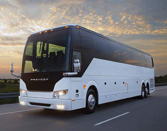 White tour bus rental with blue skies and Los Angeles sunset in the background